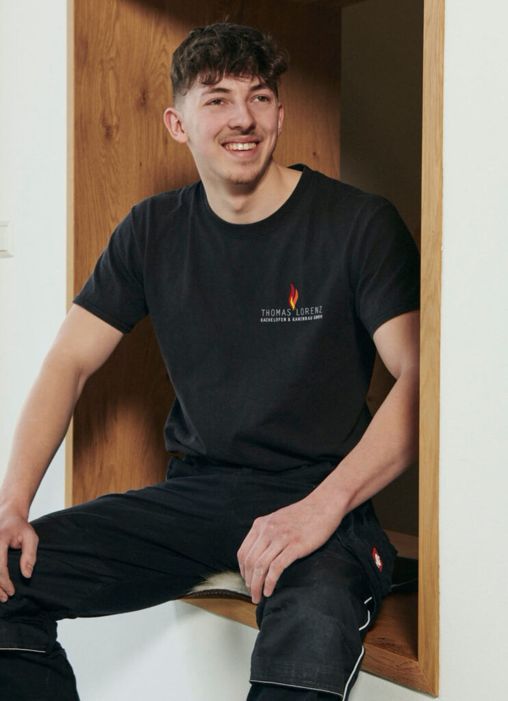 Lächelnder junger Mann mit schwarzem T-Shirt